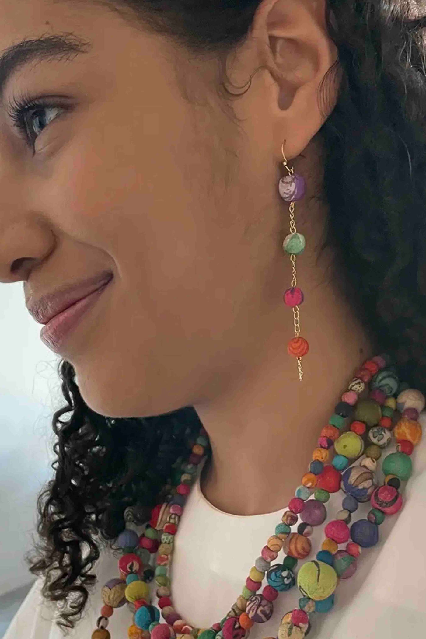 model wearing the multicolored Kantha Fluid Ellipses Earrings by World Finds with a matching necklace