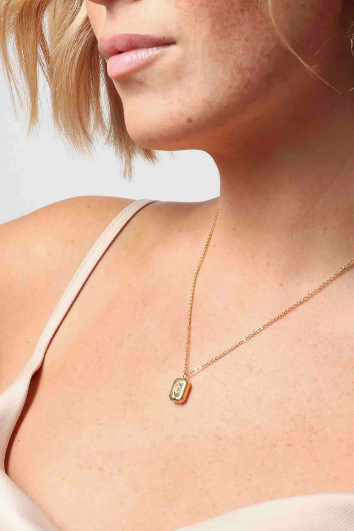 16" long Gold Orion Pendant by Marrin Costello on a model 