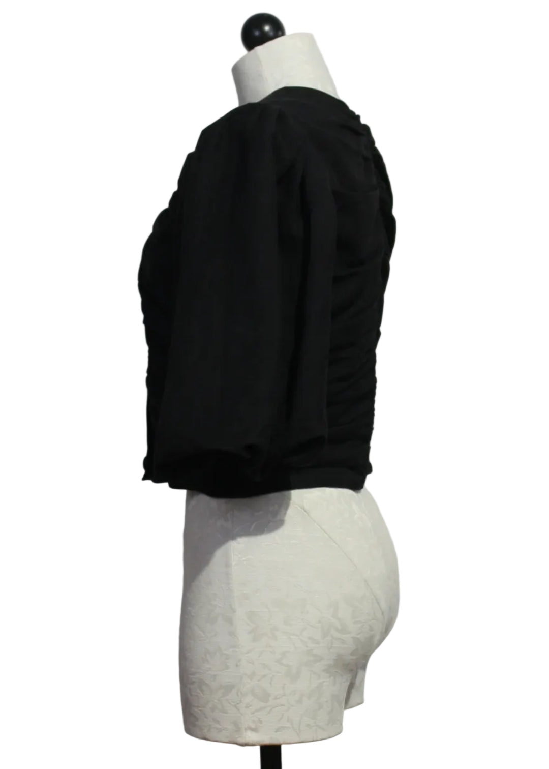 side view of The black cropped Rowan Top by Marie Oliver with short blouson sleeves and ruched detailing on the front and back.Rowan Top by Marie Oliver 