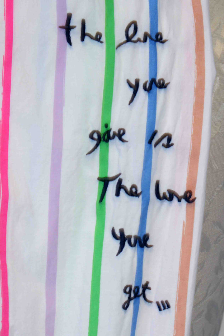 Embroidered on the left sleeve in Navy is "the love you give is The love you get."Multi Stripe Mia Shirt by Kerri Rosenthal and has a tiny Navy embroidered heart below the front pocket