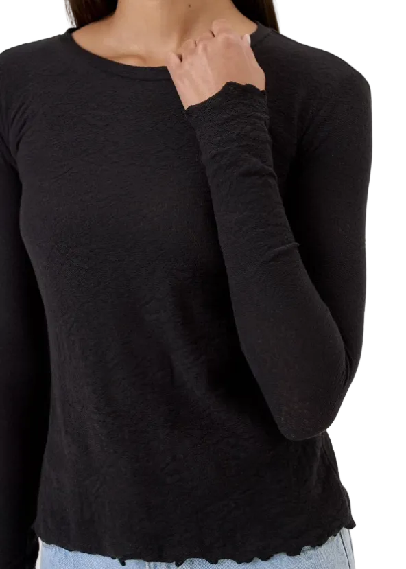 Close up view of The Cotton Jacquard Long Sleeve Tee by Goldie Tees in Black with a lettuce edge trim
