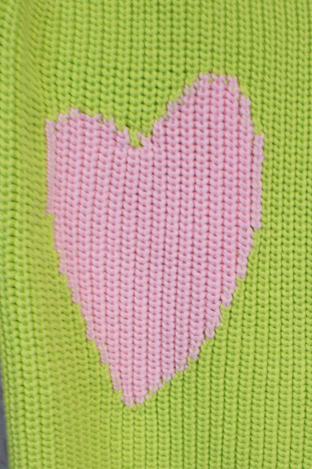close up of the heart on Lime Green Ricki Imperfect Heart Sweater by Kerri Rosenthal on each elbow sleeve
