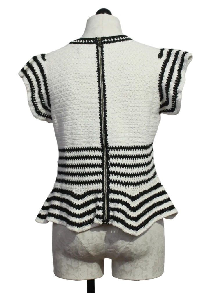back view of The knit Regatta Knit Black and White Striped Audrey Top by Marie Oliver with ruffled shoulders and a peplum bottom