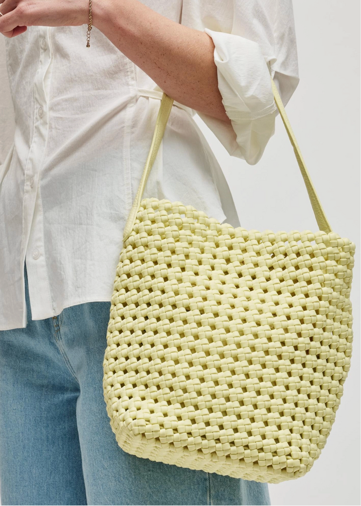 model carrying the Gaia Shoulder Bag by Sol and Selene in Butter