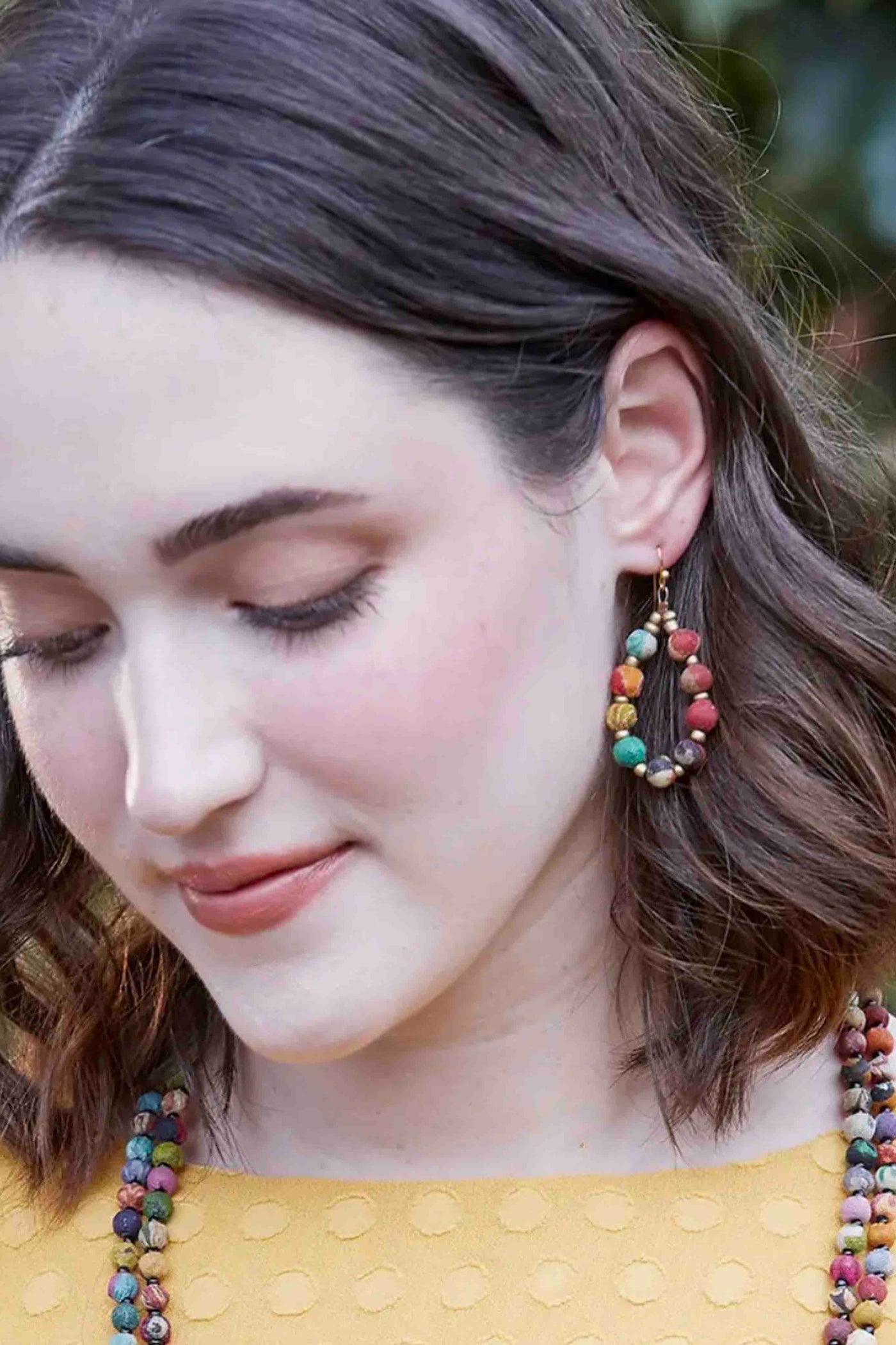 model wearing the Multicolored Kantha Beaded Teardop Earrings by World Finds and matching necklaces