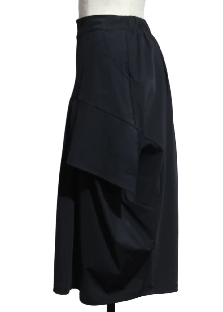 side view of Coal black The Vona Skirt by Kozan with apron-like side detail