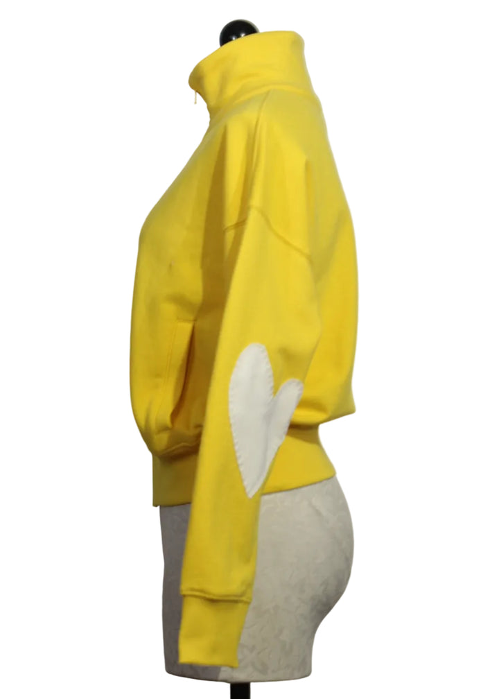 side view of Golden Yellow Colored Zip Up Mock Neck Sweatshirt by Kerri Rosenthal with cream-colored heart patches on the sleeves.