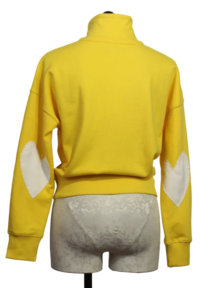 back view of Golden Yellow Colored Zip Up Mock Neck Sweatshirt by Kerri Rosenthal with cream-colored heart patches on the sleeves.