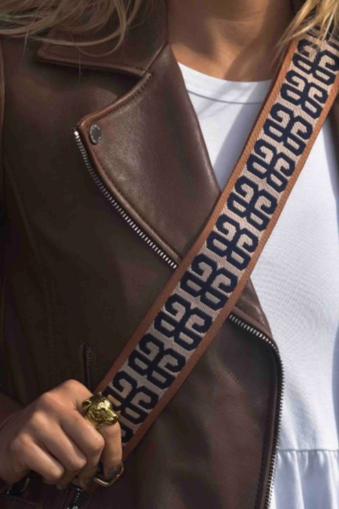 closeup on person of woven Mykonos Bag Strap by Allie June with gold hardware
