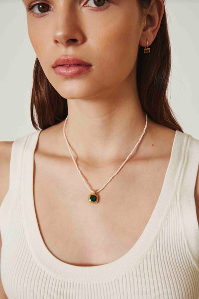 Model wearing the White Pearl Necklace with Bezel Emerald Crystal by Chan Luu