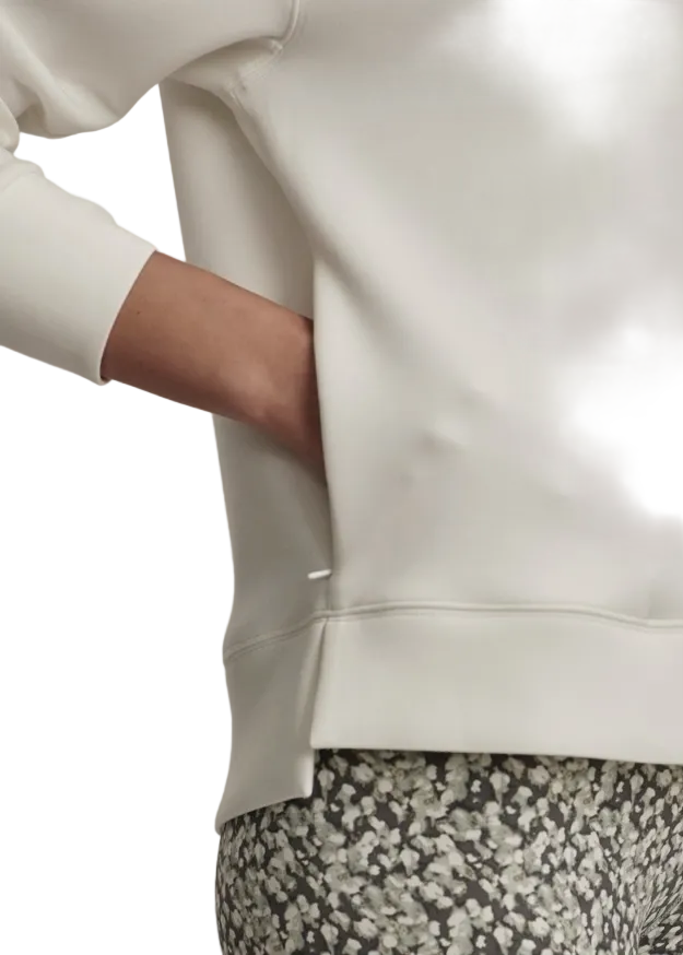 Closeup details of the pocket and hi-lo hemline on the Snow White Hooded Karo Half Zip Midlayer by Varley