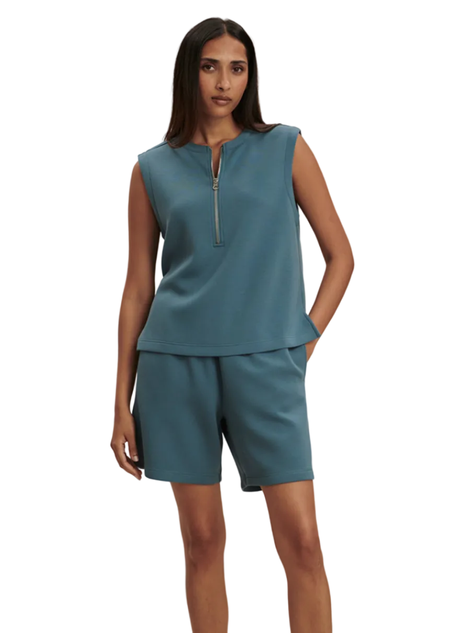  model wearing the Simmons Half Zip Tank by Varley in Mallard Blue and the matching Rumor 6.5 Long Short in Mallard Blue by Varley