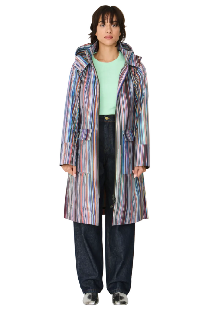 Model wearing the striped Kresua Jacket in grems by SKFK, a stylish knee-length raincoat