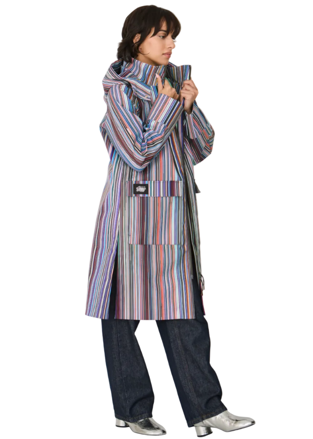 side view of Model wearing the striped Kresua Jacket in grems by SKFK, a stylish knee-length raincoat