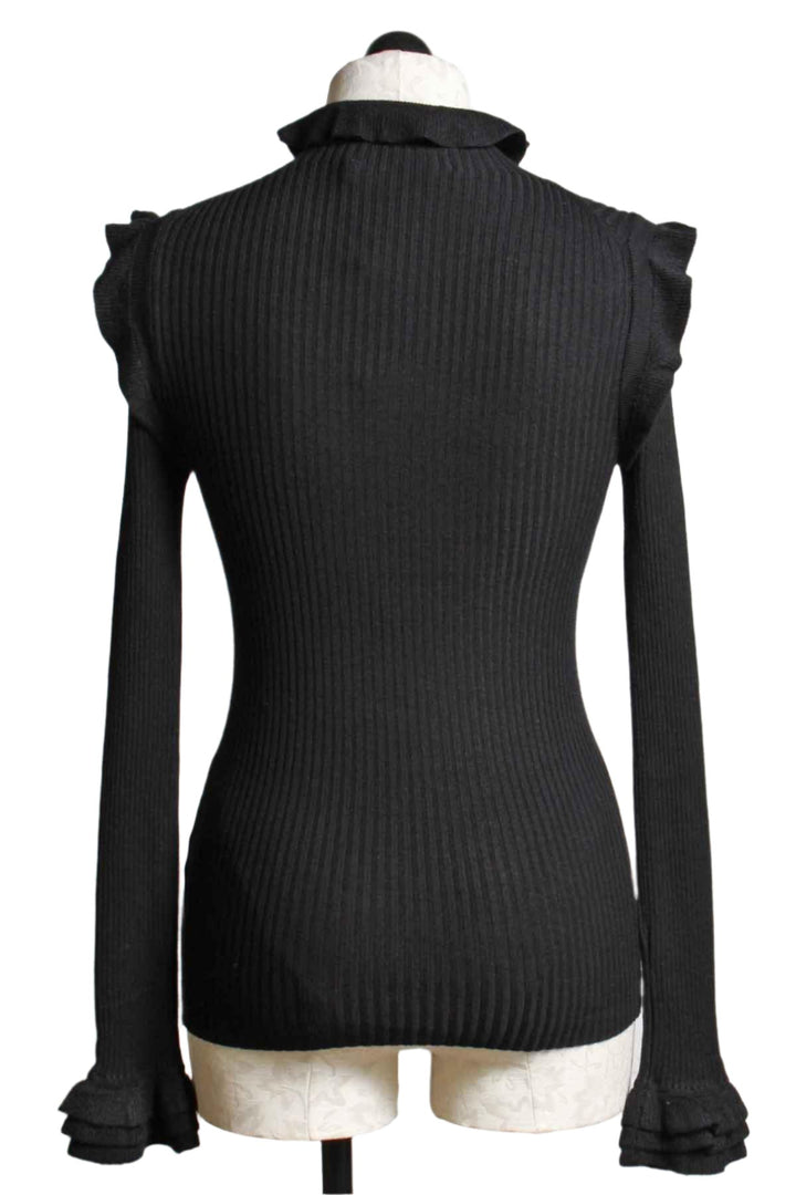 back view of Black ribbed Turtleneck by Marie Oliver with tiny ruffle shoulder neckline and bottom of sleeve