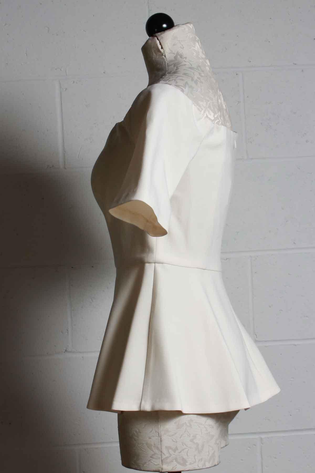 side view of ivory Elegant fitted Off the shoulder Forbid Top by Trina Turk with a peplum bottom