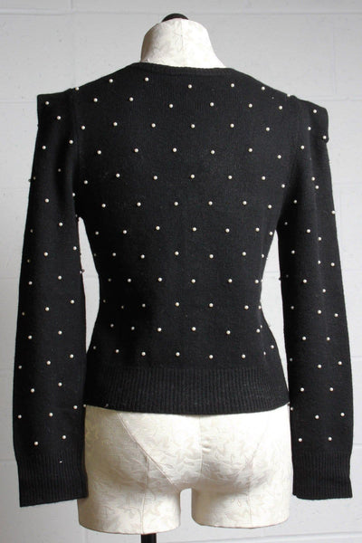 back view of black puffed ribbed sleeve cashmere blend cardigan with pearls and crystal buttons