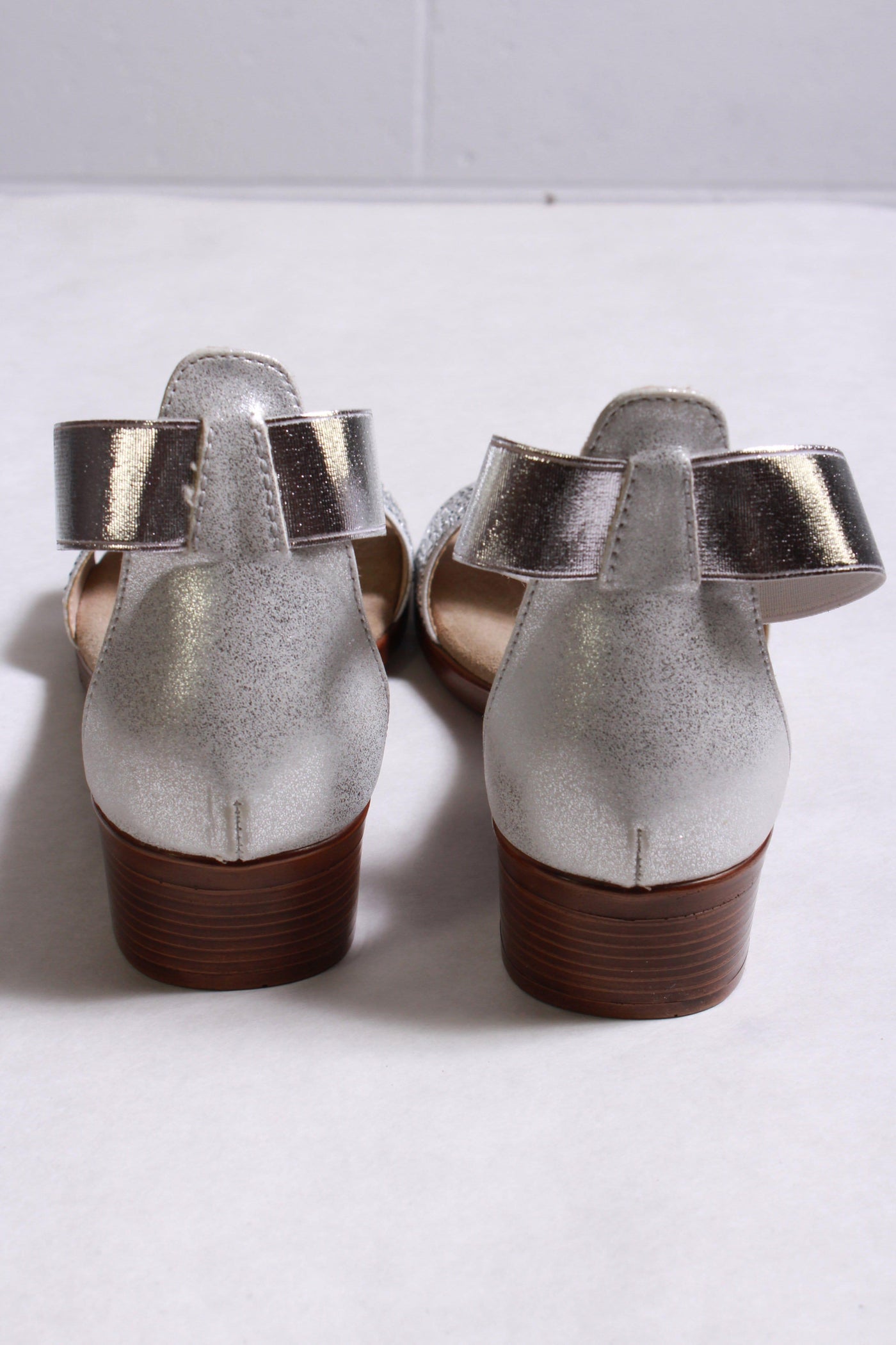 back of silver sandal has a sparkled toe strap and a 1" heel  with an elastic band ankle strap