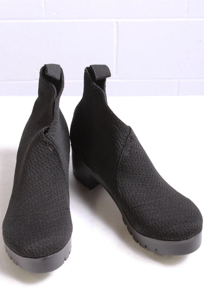 Side view of black Platform bootie by Charleston Shoe Company with a rubber lug bottom sole and elastic upper