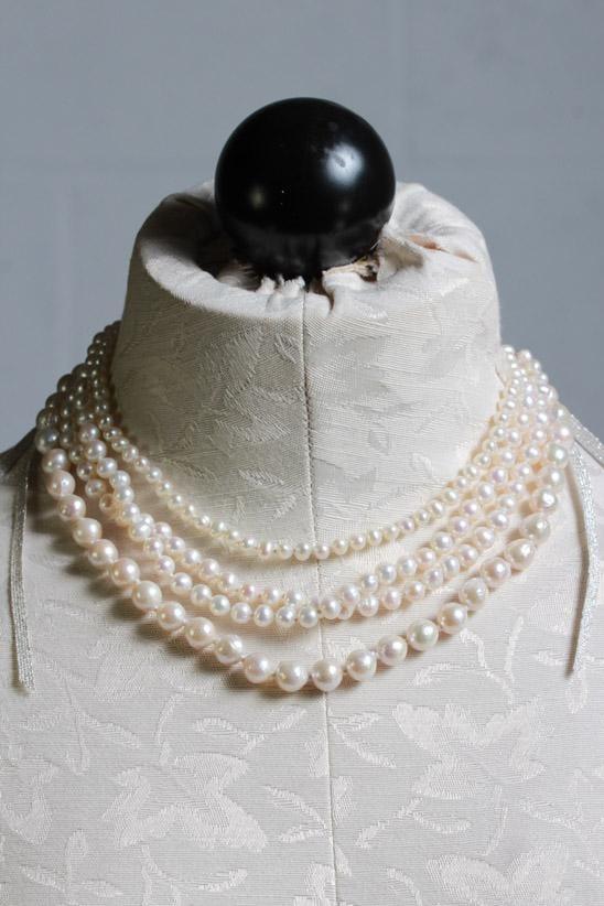adjustable white pearl 4 strand necklace from a choker length down by sliding a pearl down the silver metallic tasseled cords hanging down the back