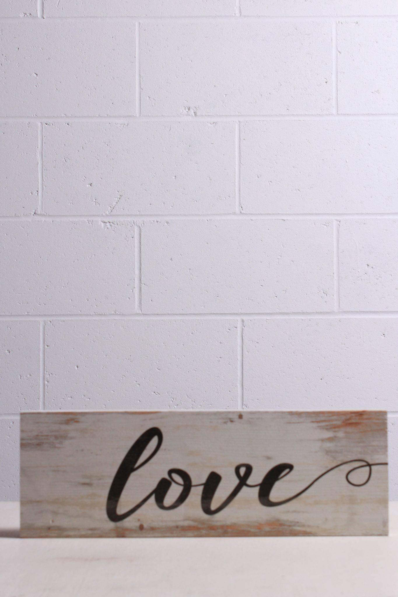 Lovely white washed plank with "Love" in cursive printed across the front