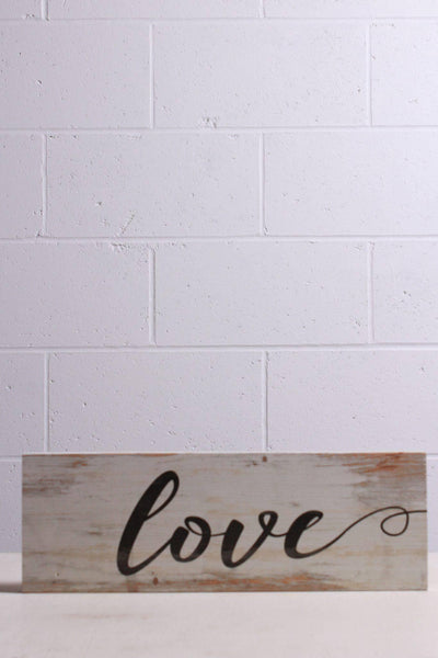 Lovely white washed plank with "Love" in cursive printed across the front