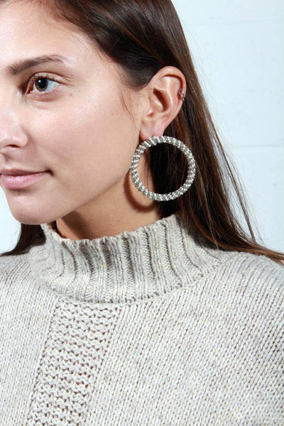 2 in circular post earring with silver and white beads wrapped around the hoop